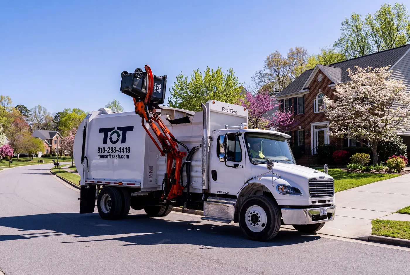 Tons of Trash residential pickup truck collecting a curbside bin in eastern North Carolina