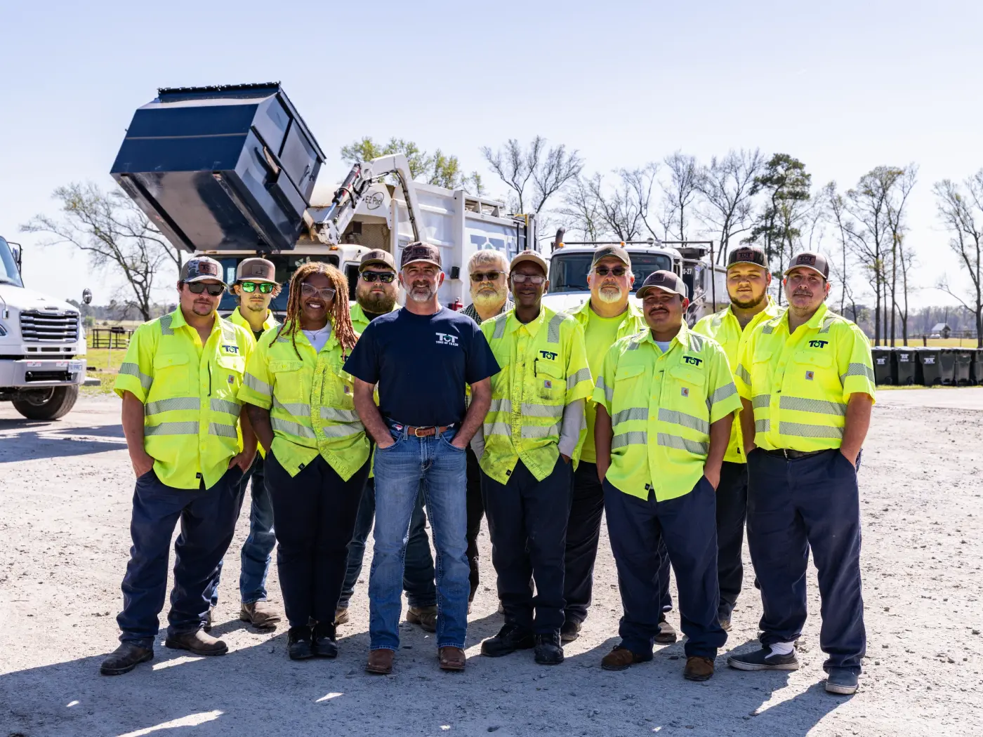 Tons of Trash crew in hi-vis vests standing with a waste truck in eastern North Carolina