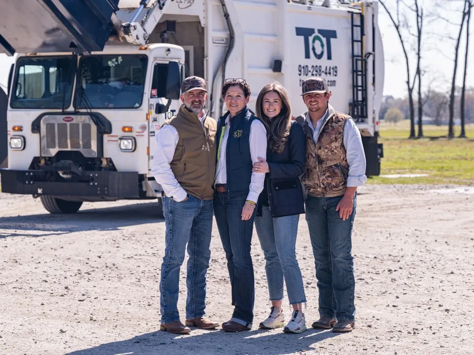 The Tons of Trash family standing in front of a TOT truck in eastern North Carolina